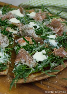Pizza mit Parmaschinken. Rucola und Parmesan