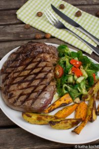 Steak mit zweierlei Kartoffelspalten und Salat mit Pestokäse und