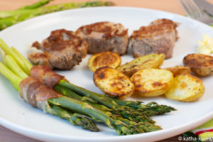 Schweinemedaillons mit grünem Spargel im Speckband